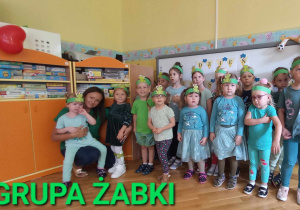 Dzieci stoją w grupie, która nazywa się Żabki.