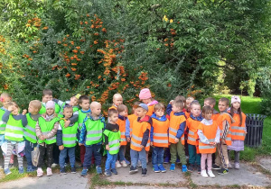 Dzieci stoją na tle krzewów Ogrodu Botanicznego w Łodzi.