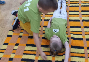 Dzieci pokazują ułożenie pozycji bocznej bezpiecznej.