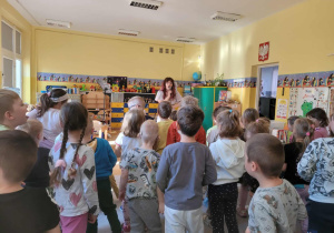 Dzieci wspólnie z Panią Nutką śpiewają, stojąc.
