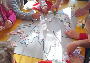 Plastykoterapia w grupie 3. Dzieci wyklejają kontur liścia podartymi na drobne elementy kawałkami papieru.