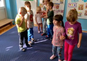 Teatroterapia w grupie I. Dzieci stoją w parach na dywanie.