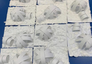 Plastykoterapia grupa 1. Prace przestrzenne - igloo z pasków białego papieru.