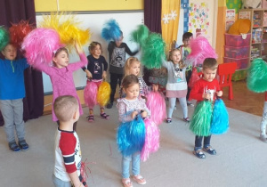Choreoterapia grupa 5. Grupa dzieci tańczy z wykorzystaniem kolorowych pomponów.