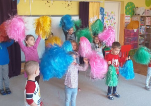 Choreoterapia grupa 5. Grupa dzieci tańczy z wykorzystaniem kolorowych pomponów.