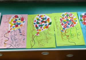 Plastykoterapia grupa 5. Prace dzieci przedstawiające karnawałowe, kolorowe baloniki z serpentynami.