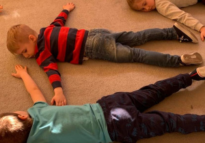 Teatroterapia grupa 1. Dzieci leżą na dywanie z zamkniętymi oczami. odtwarzają fragment bajki.