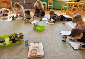 Biblioterapia w gr. 4. Dzieci siedzą w dużym kole i wykonują ćwiczenie do wysłuchanej historii.