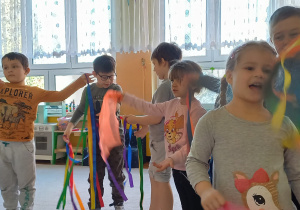 Choreoterapia grupa 5. Grupa dzieci tańczy wg układu choreograficznego do piosenki "Pada deszcz..."