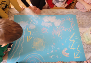 Plastykoterapia grupa 5. Dzieci wykonują pracę plastyczną pt. "Wiosenna pogoda" z wykorzystaniem kredy.