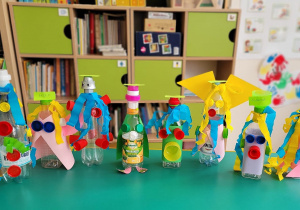 Plastykoterapia grupa 5. Prace plastyczne dzieci przedstawiające kolorowe postaci z plastikowych butelek.