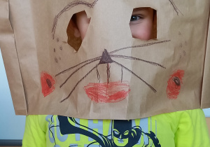 Teatroterapia grupa 5. Chłopczyk przedstawia maskę kota, wspólnie wykonaną przez dzieci do inscenizacji przedstawienia o kotku.