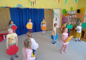 Choreoterapia grupa 5. Na zdjęciu widać grupę dzieci tańczących z kolorowymi krążkami.