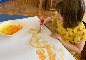 Gr. 1. Dziewczynka maluje farbami.