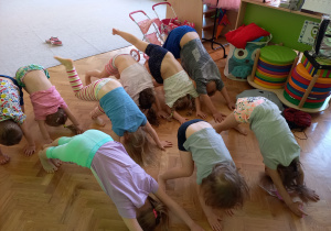 Grupa 5. Na zdjęciu widać grupę dzieci wykonujących skłon z głową w dół.