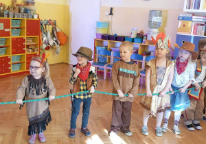 Dzieci na Balu Karnawałowym trzymają linę.