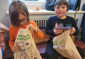 Dwóch chłopców trzyma torby z prezentami.