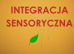 Czerwony napis "Integracje sensoryczna" na pomarańczowym tle, z zielonym listkiem.