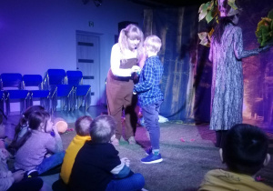 Chłopiec stoi na scenie z aktorką.