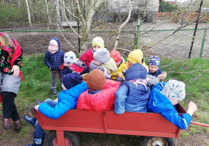 Dzieci siedzą na wiejskim wózku.