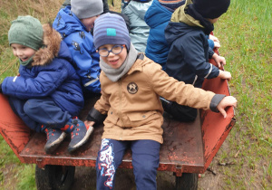 Dzieci siedzą na wiejskim wózku.