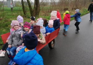 Dzieci jadą w wózku wiejskim na pole.