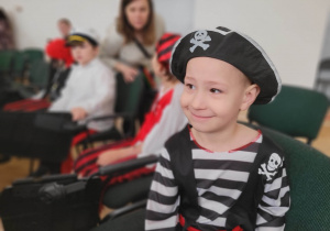 Chłopiec przebrany za pirata siedzi na miejscu publiczności po zakończonym występie.