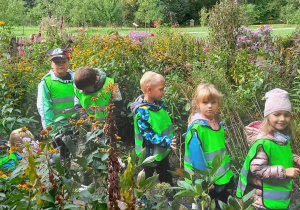Dzieci w ogrodzie przy chacie w skansenie Ogrodu Botanicznego w Łodzi.
