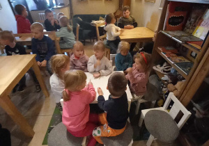 Dzieci z grupy Liski siedzą przy stolikach.