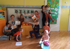 Dzieci z grupy Liski stoją z ilustratorką na tle tablicy.