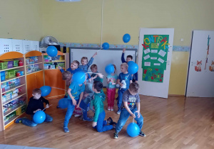 Dzieci z grupy Liski tańczą z niebieskimi balonami.