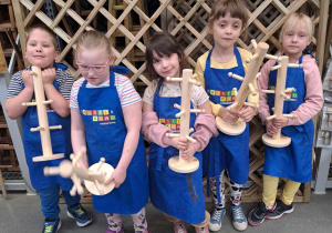 Dzieci pokazują stojak na filiżanki w Castoramie na warsztatach stolarskich.