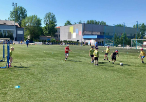 Drużyna PM 221 rozgrywa mecz piłki nożnej na boisku.