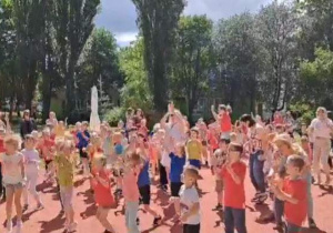 Dzieci tańczą na boisku.