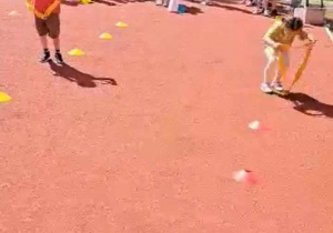 Dzieci wykonują ćwiczenia sportowe na boisku.
