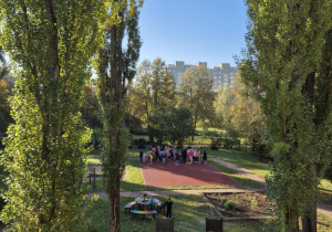 Dzieci stoją na boisku przedszklonym, uczestnicząc w zawodach sportowych.