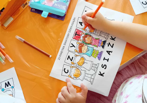 Dzieci kolorują karty pracy z okazji Światowego Dnia Książki.