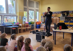 Iluzjonista trzyma w ręce czarna chustkę.