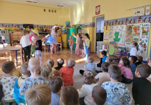 Dzieci z wykorzystaniem kolorowych chust tańczą i śpiewają z Panią Nutką.