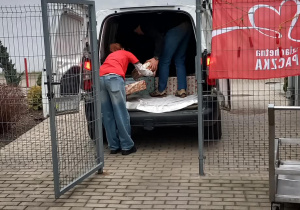 Wolontariusz wypakowuje paczki przywiezione z Przedszkola Miejskiego 221 do Bajkowej Szkoły.