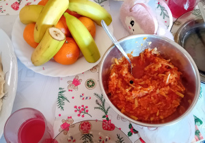 Potrawy stoją na stole świątecznego obiadu (ziemniaki, ryba, owoce, potrawka z marchewki)