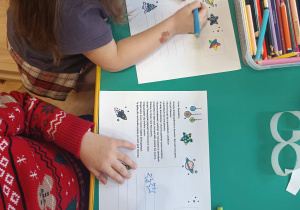 Dzieci przygotowują kartki świąteczne dotyczące Centrum Europejskiej Agencji Kosmicznej.