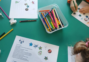 Dzieci przygotowują kartki świąteczne dotyczące Centrum Europejskiej Agencji Kosmicznej.