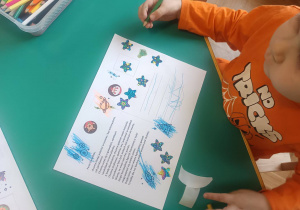 Dzieci przygotowują kartki świąteczne dotyczące Centrum Europejskiej Agencji Kosmicznej.