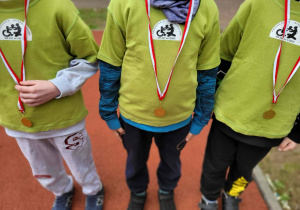 Dzieci prezentują medale sportowe.