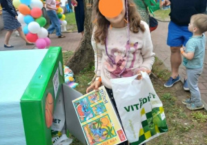 Dziewczynka trzyma upominki z "Magic box".