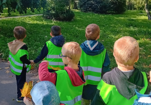 Grupa dzieci idzie sprzątać pobliskie otoczenie.