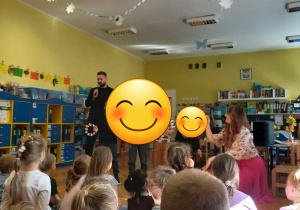 Dzieci stoją na środku sali wykonując z Panią "Nutką' wraz z zaproszonym gościem wspólnie hejnał Łodzi "Prząśniczki".