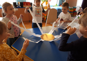 Realizacja ogólnopolskiego projektu edukacyjnego: "Wspólnie Świętujemy Urodziny F. Froebla". Dzieci wykonały słońce. Stoją w kole trzymając wycięte z kartonu promienie.