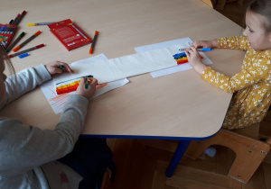 Realizacja ogólnopolskiego projektu edukacyjnego: "Wspólnie Świętujemy Urodziny F. Froebla". Dwie dziewczynki kolorują mazakami końce ręcznika papierowego.